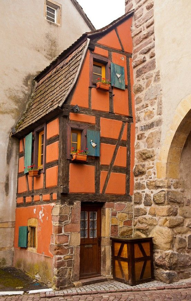 AI caption: a small house with a red roof and shutters, old german