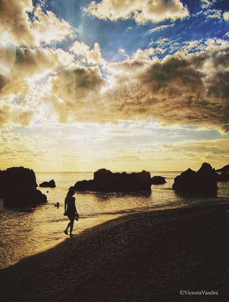 AI caption: a person walking on the beach at sunset, abstract