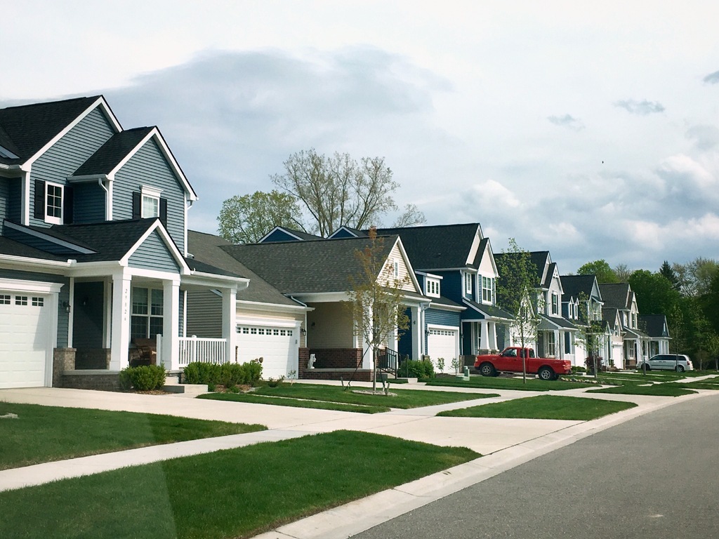 AI caption: a row of houses with a car parked in front of them, residential