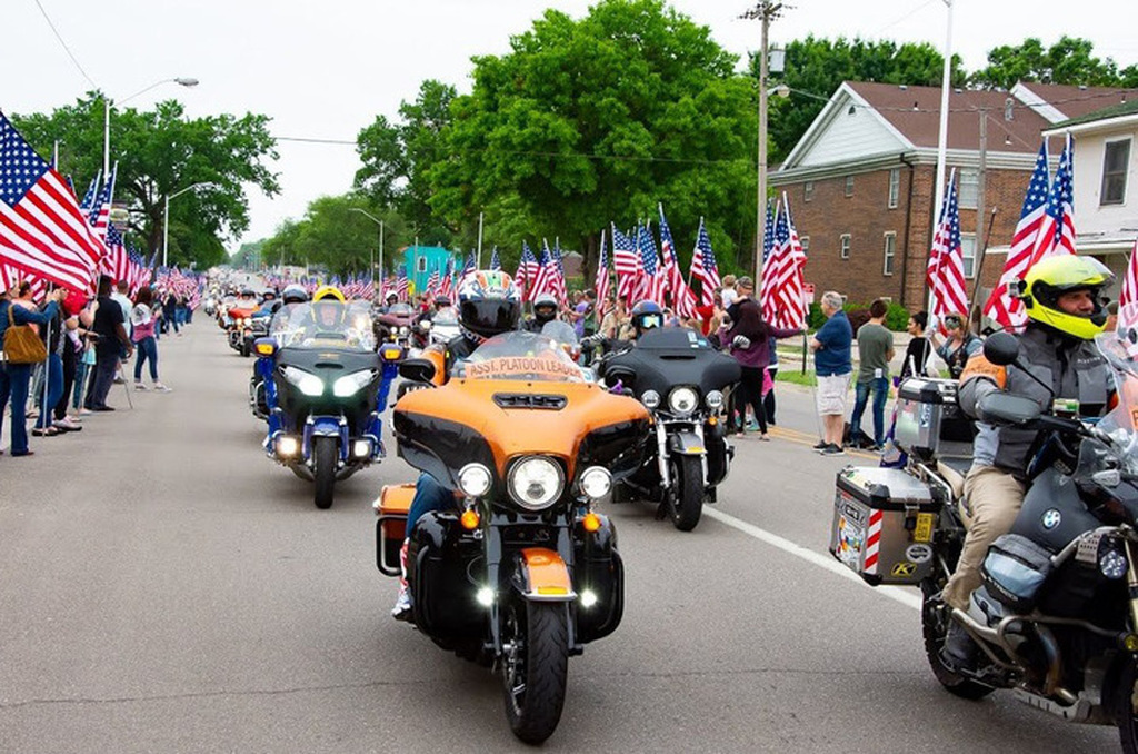 AI caption: a parade of motorcycles with american flags on the road, portrait