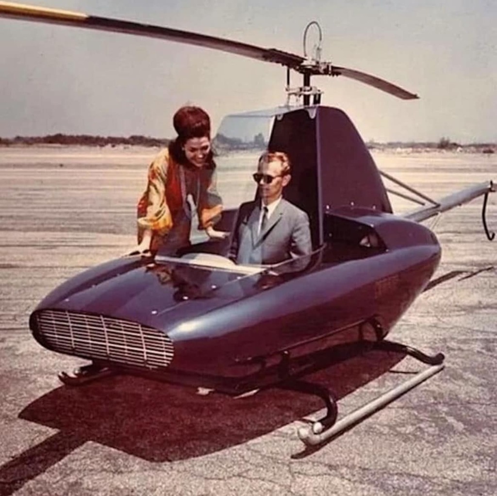 AI caption: a man and woman standing next to a small helicopter, black and white