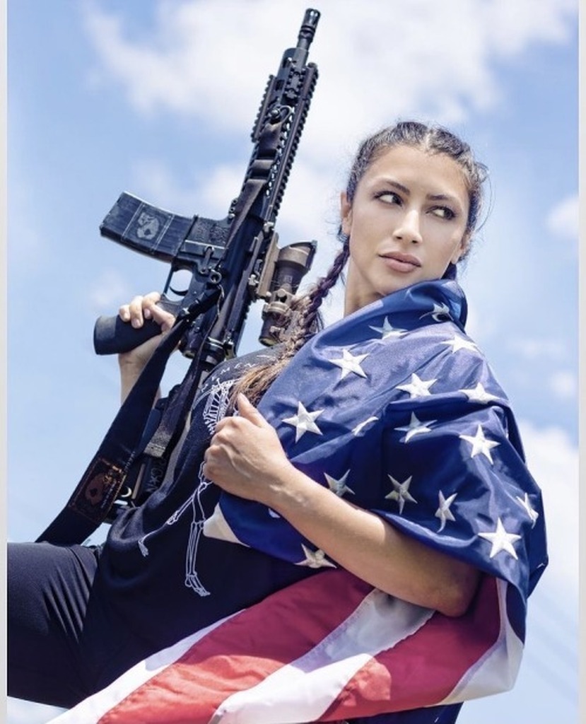 AI caption: a woman holding an american flag and an ag rifle, portrait