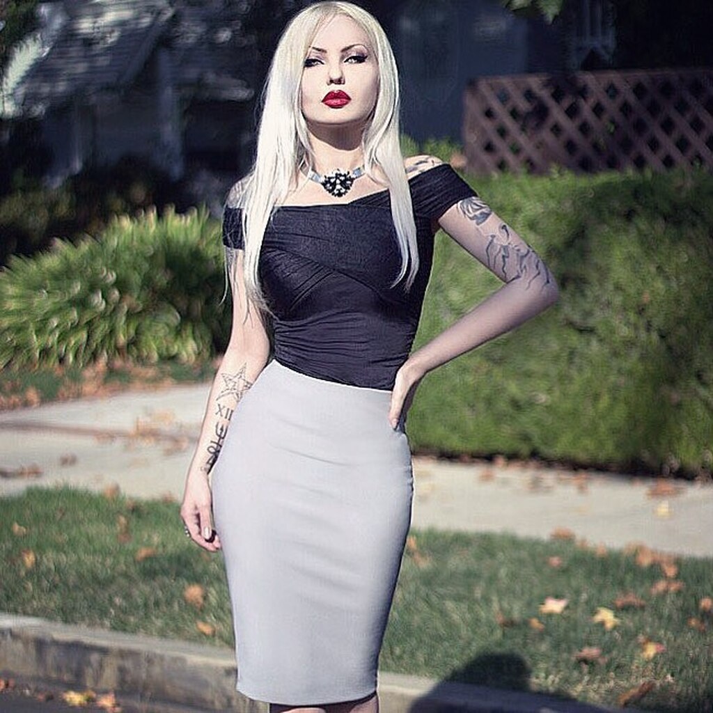 AI caption: a woman in a black and silver costume, black and white a woman in a white tank top and black shorts, the tattoos on the woman's body, gothic a woman in a grey pencil skirt posing, the woman is wearing a skirt