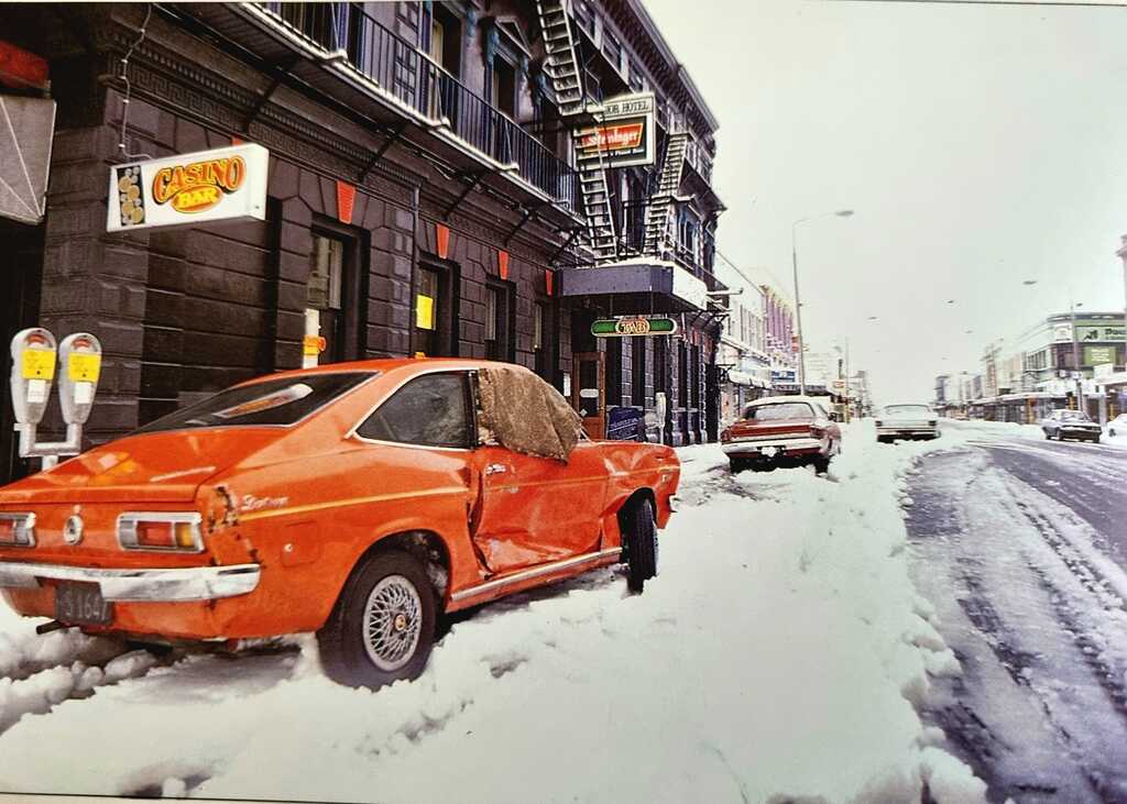 AI caption: an orange car parked in the snow, a photograph