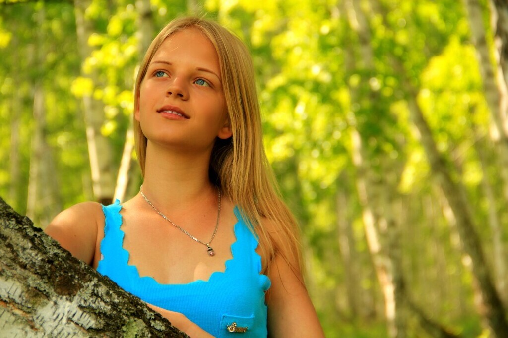 AI caption: a woman in a blue shirt, portrait a beautiful woman in a black dress posing for a picture, the girl is posing in a black dress, portrait a young woman is leaning against a tree, the girl is posing in a tree